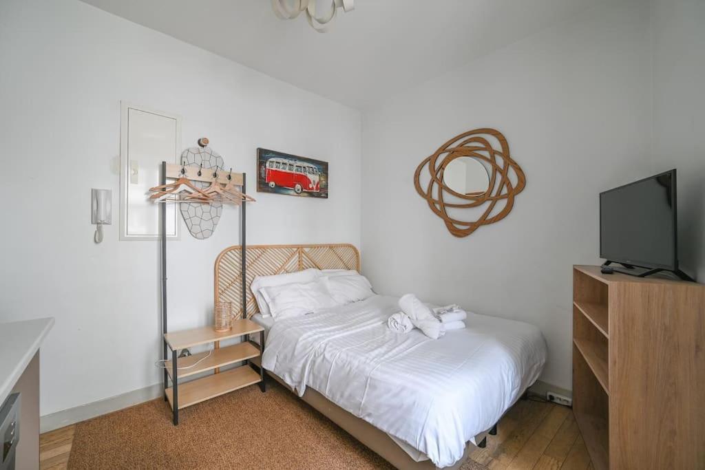 - une petite chambre avec un lit et une télévision dans l'établissement Paris, Opéra 2D...pour un séjour magique, à Paris
