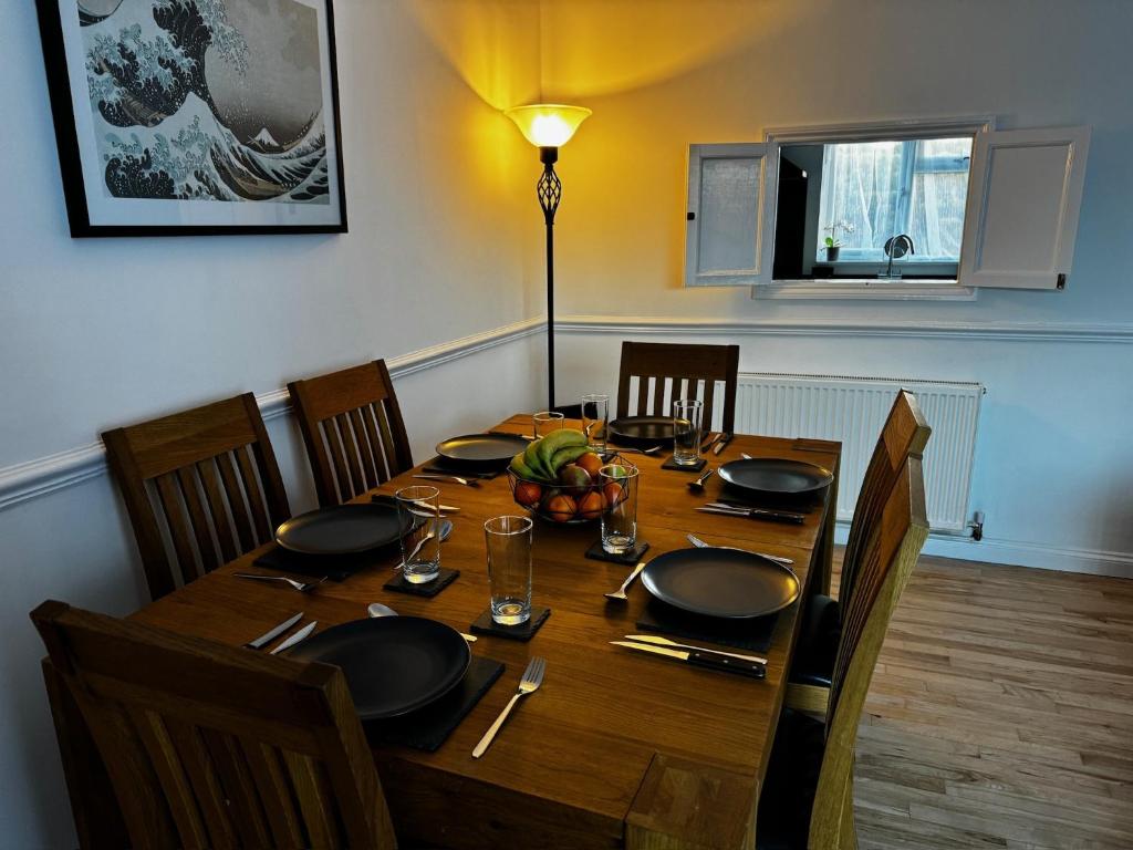 a dining room table with chairs and a table with plates and glasses at Station house in Ramsgate