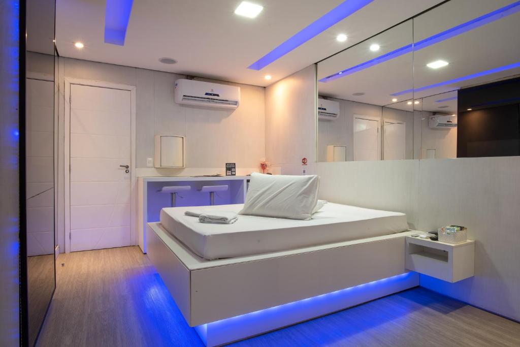 um quarto branco com uma cama e um espelho em Motel fantasy 4 (adult Only) em Belo Horizonte