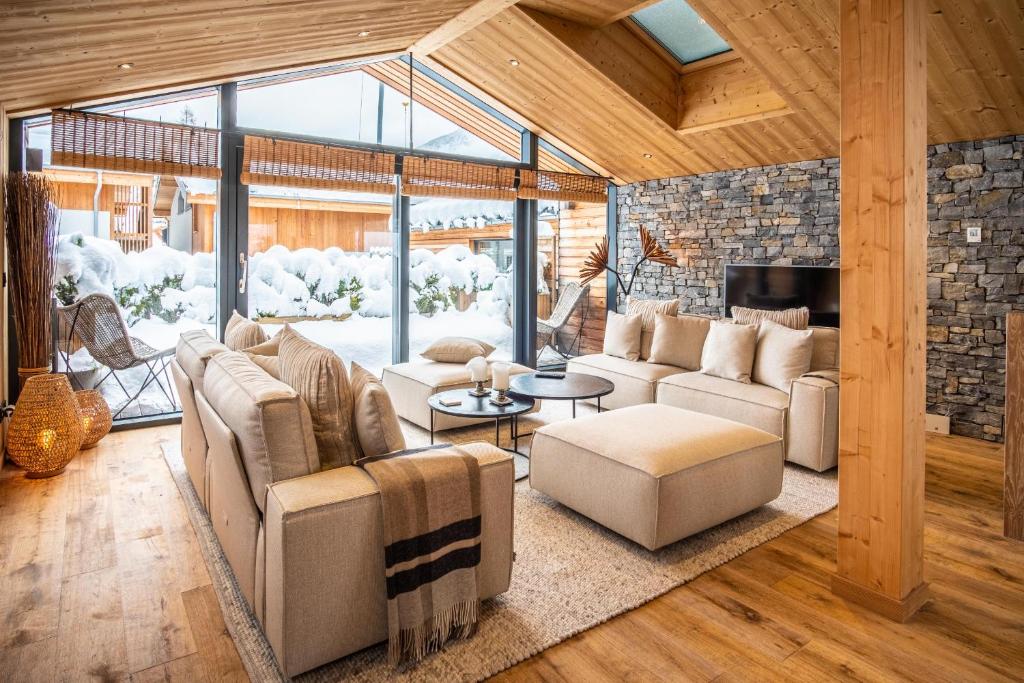 un salon avec des canapés et une cheminée dans l'établissement Chalet Sia - Contemporain - Sauna prive, à Chamonix-Mont-Blanc