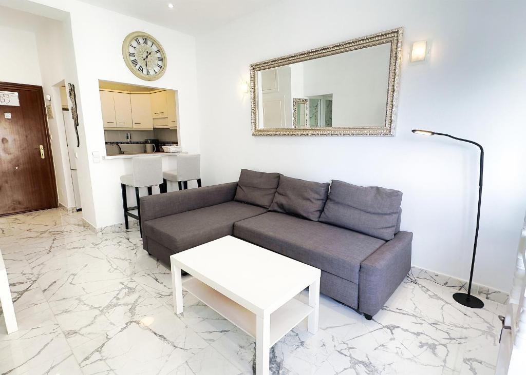 uma sala de estar com um sofá e um espelho em SKOL 424 Stunning One-bedroom apartment with sea views em Marbella