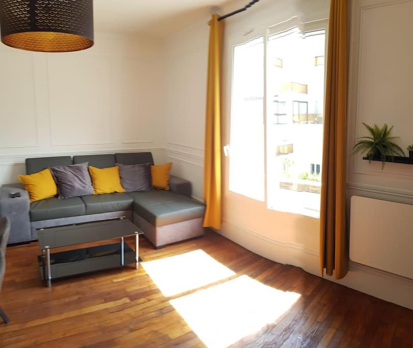 ein Wohnzimmer mit einer Couch und einem Fenster in der Unterkunft Le 131 in Reims