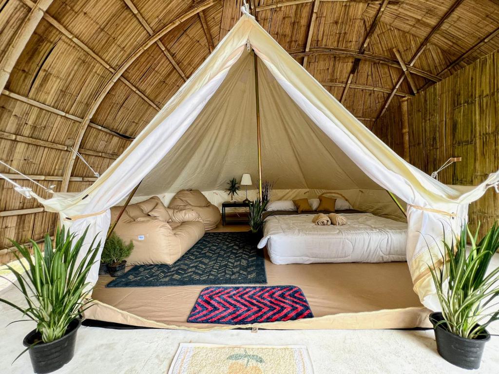 Zelt mit 2 Betten und 2 Topfpflanzen in der Unterkunft The Por Beach in Ko Por