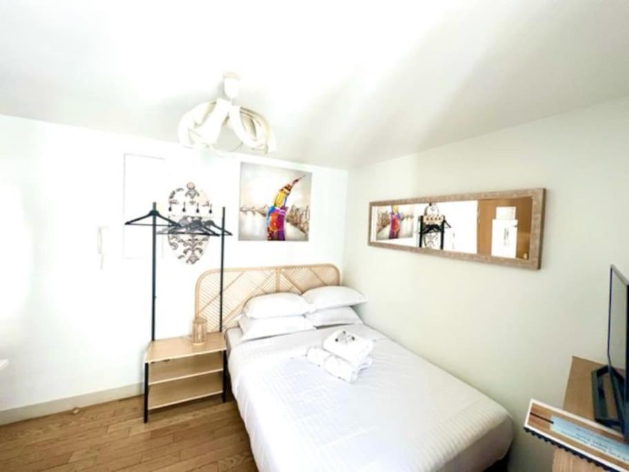 une chambre avec un lit et deux tableaux au mur dans l'établissement Paris, Opéra 4D...en plein coeur de la Paris, à Paris