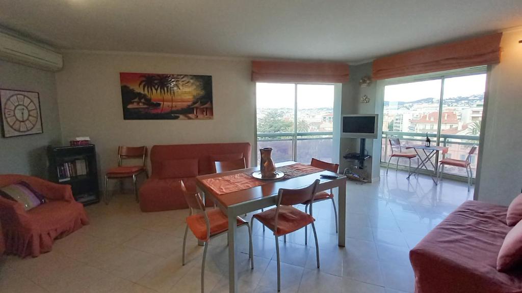 un salon avec une table, des chaises et un canapé dans l'établissement Le République 2, à Cannes