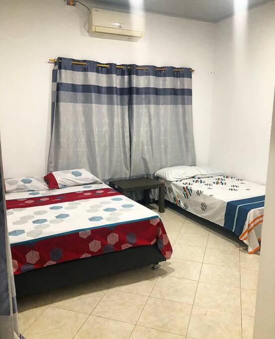 een kamer met twee bedden en een raam bij Apto Tomás in Doradal