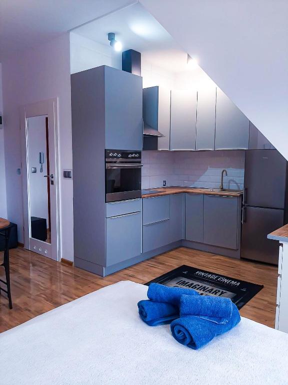 a kitchen with white cabinets and a stove top oven at Kameralny Apartament in Szczytno
