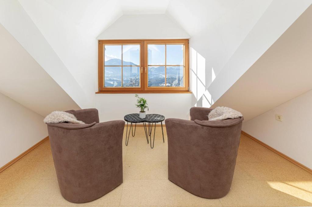 Zimmer im Dachgeschoss mit 2 Stühlen und einem Tisch in der Unterkunft Guest House Štruc in Slovenj Gradec