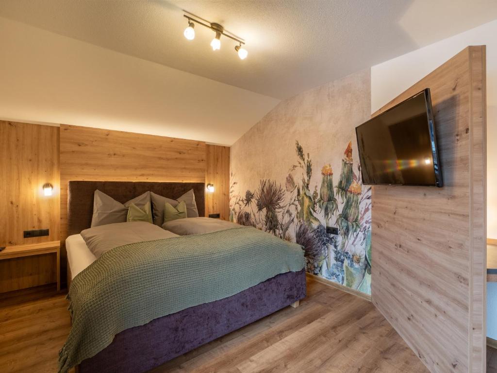 Schlafzimmer mit einem Bett und einem Flachbild-TV in der Unterkunft Gartenhaus Zur Kröllin in Mayrhofen