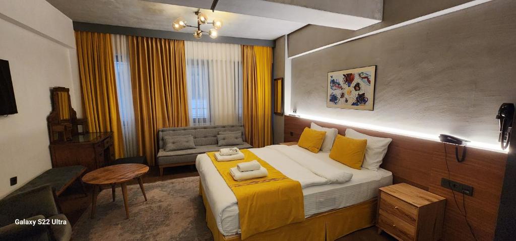 a bedroom with a large bed with yellow pillows at Aleksandr Pera Hotel in Istanbul
