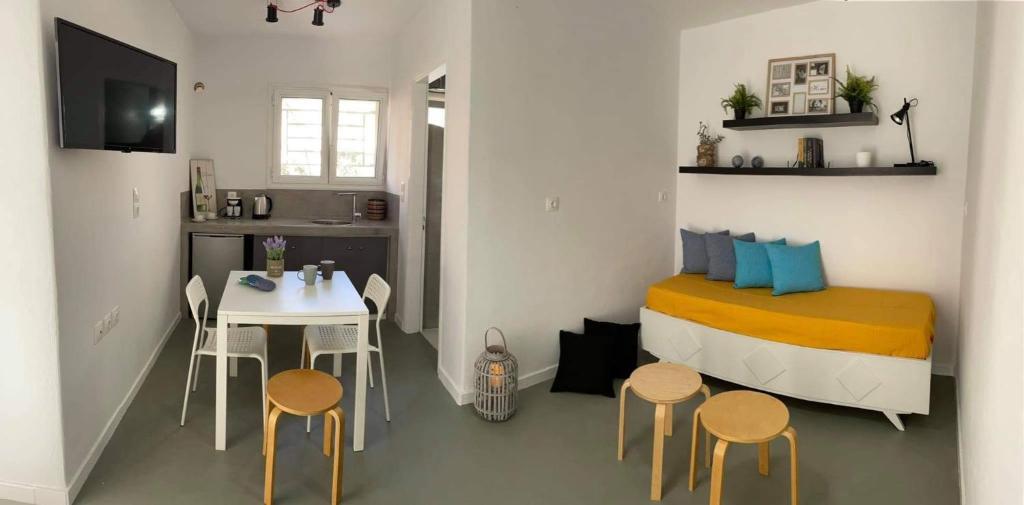 mały pokój z łóżkiem, stołem i krzesłami w obiekcie Sabbia Calda Apartments w mieście Perissa