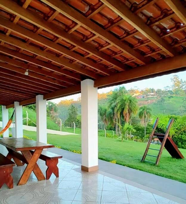 a porch with a picnic table and a view of a park at Chacara Antonio dos Reis (Piaui) in Mairinque