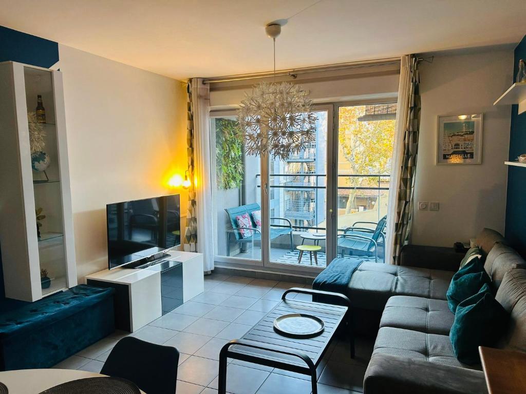 sala de estar con sofá y TV en Le 13OR - Appartement plein centre parking et terrasse en Marsella