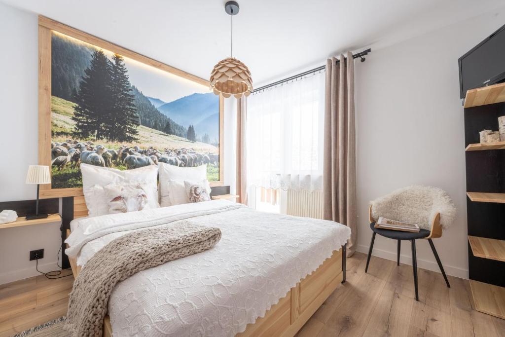 a bedroom with a bed with a picture of a herd of sheep at Pokoje Widokowe Sywarne in Kościelisko