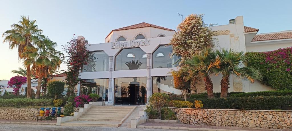 een gebouw met palmbomen ervoor bij Eden Rock Hotel Namaa Bay in Sharm El Sheikh
