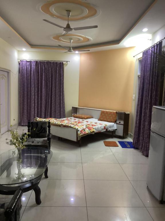 Sala de estar con cama y mesa en Trikuta Homestay, en Jammu