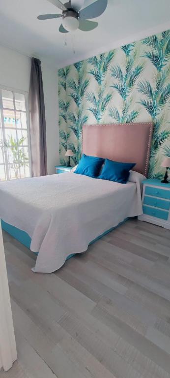 a bedroom with a large bed with blue pillows at Apartamentos Ana's Cozy Inns in Torremolinos