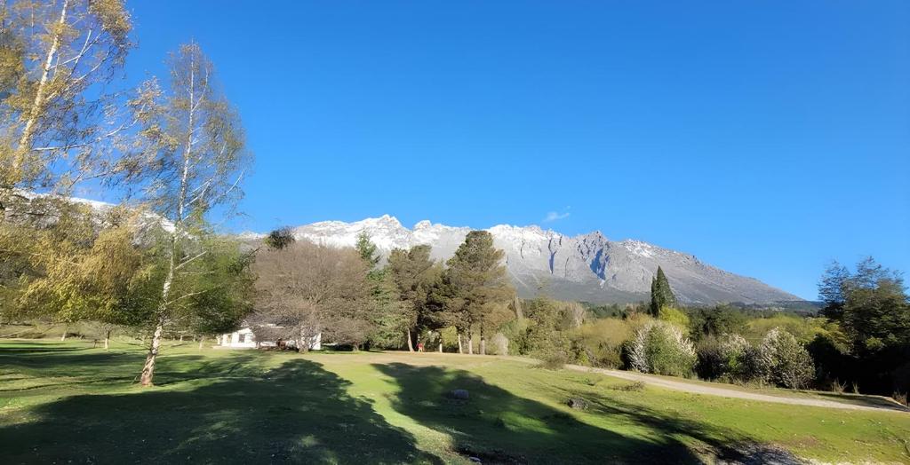 um campo de golfe com uma montanha ao fundo em Chacra Esaki em El Bolsón