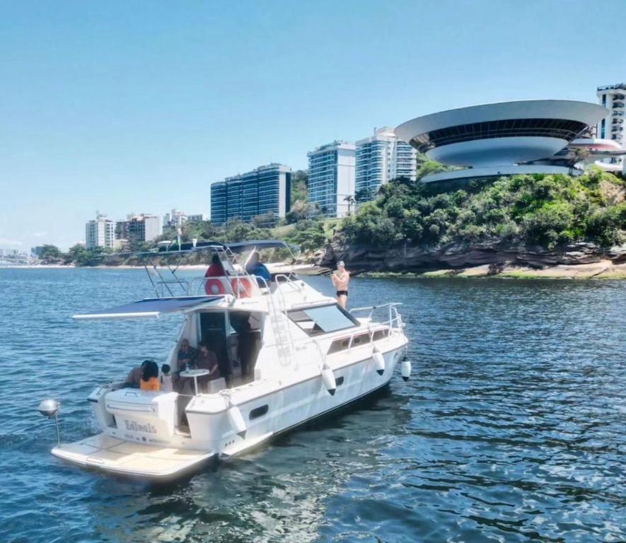 a white boat in the water with people on it at Passeios Privativos de Lancha RJ in Rio de Janeiro