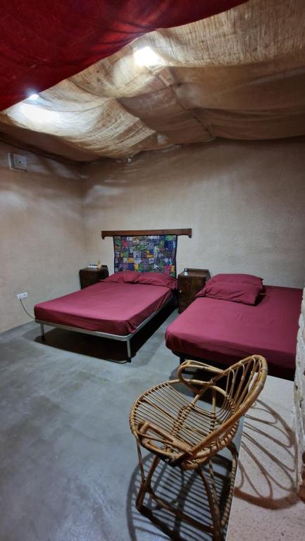 Habitación con 2 camas y una silla. en EL CAU DE CAL VIOLA, en Torroja