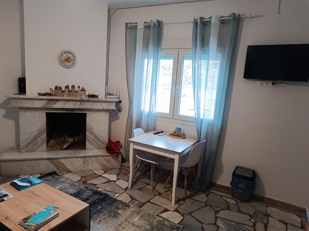 Studio με όλες τις ανέσεις في Vétrina: غرفة معيشة مع طاولة ونافذة