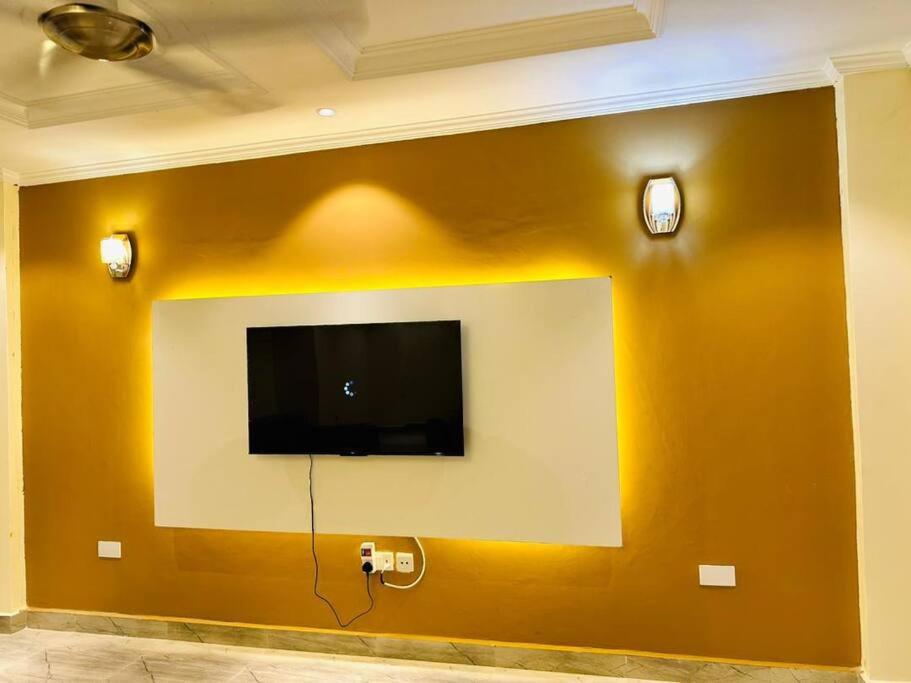 a wall with a flat screen tv on a wall at Oceans-Opulence/3BR-5 BEDS in Dar es Salaam