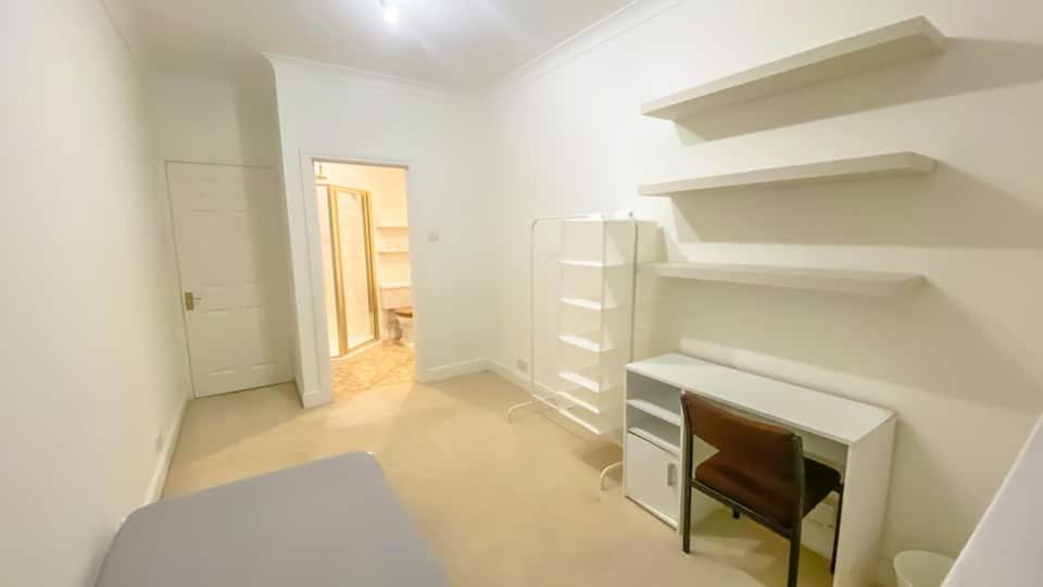 a white room with a desk and shelves at Homestay - En-suites in New Malden