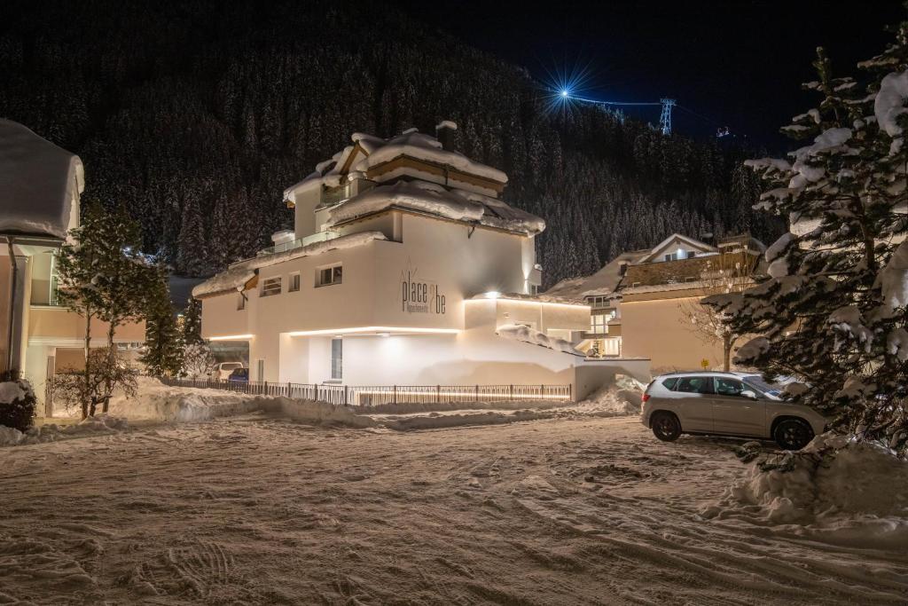 una casa con un coche aparcado delante de ella por la noche en Place2be en Ischgl