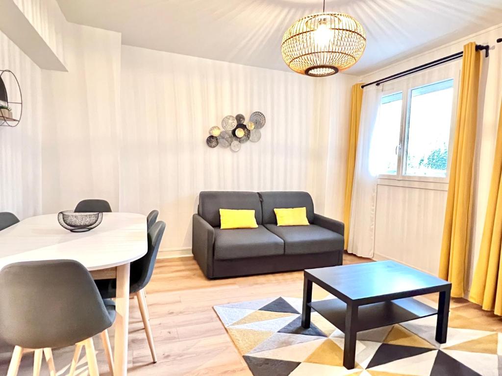 - un salon avec une table et un canapé dans l'établissement Stay house to Poitiers, à Poitiers