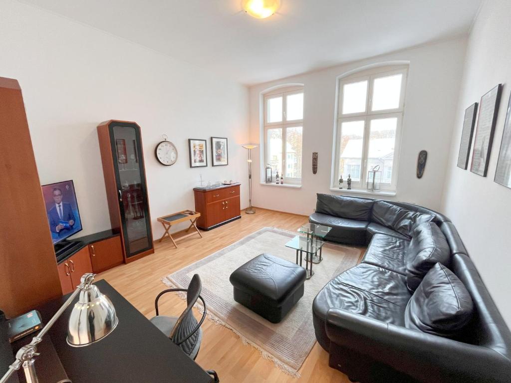 Una sala de estar con un sofá de cuero y una mesa. en Ferienwohnung Bülowstraße, en Heringsdorf