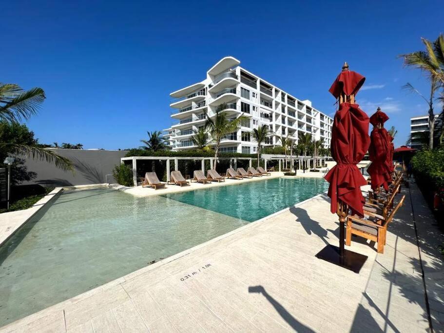 un complejo con piscina con sillas y un edificio en Apartamento en Cartagena - Morros Zoe, en Cartagena de Indias