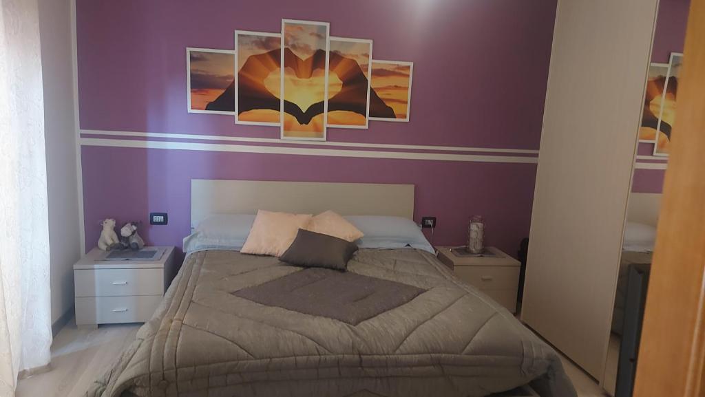 1 dormitorio con 1 cama grande y paredes moradas en Appartamento Amy, en Perugia