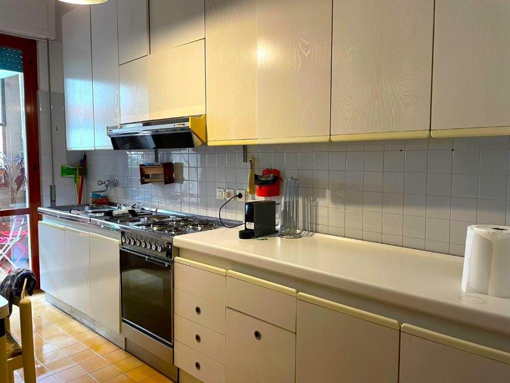 a kitchen with white cabinets and a stove at -Secret View - Marina di Carrara in Carrara