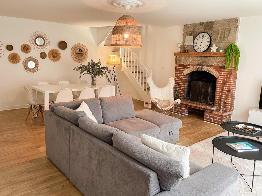 ein Wohnzimmer mit einem Sofa und einem Kamin in der Unterkunft Maison spacieuse et chaleureuse in Condé-sur-Sarthe