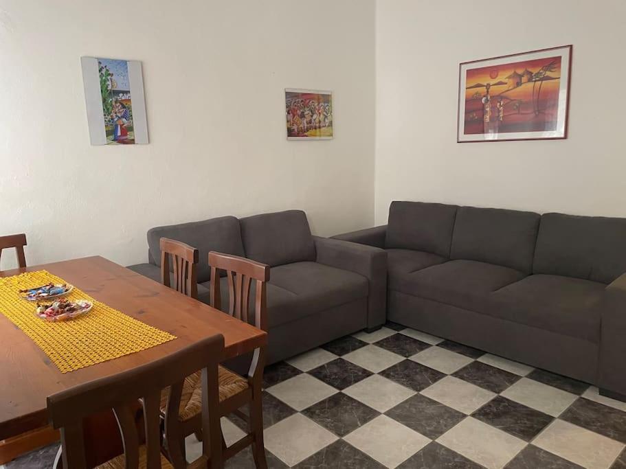 een woonkamer met een bank en een tafel bij Charming Sardinian House in Cuglieri