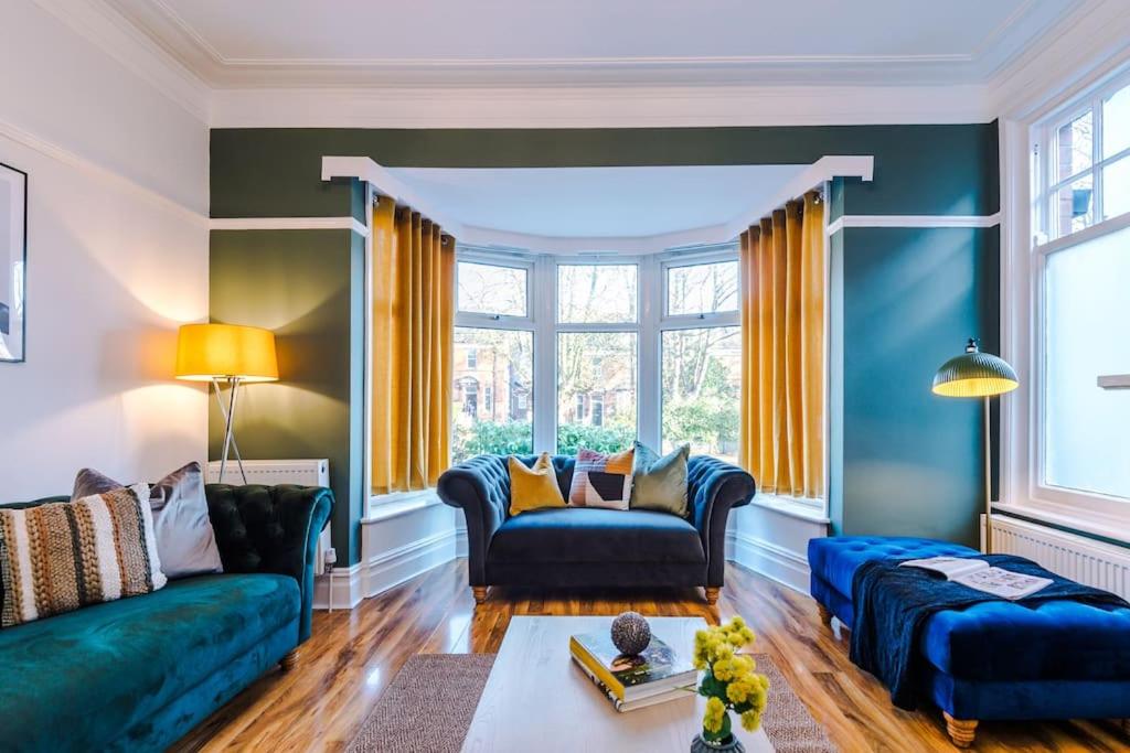 een woonkamer met twee blauwe banken bij Huge House in Leeds 6BR sleeps13 by PureStay Short Lets in Meanwood