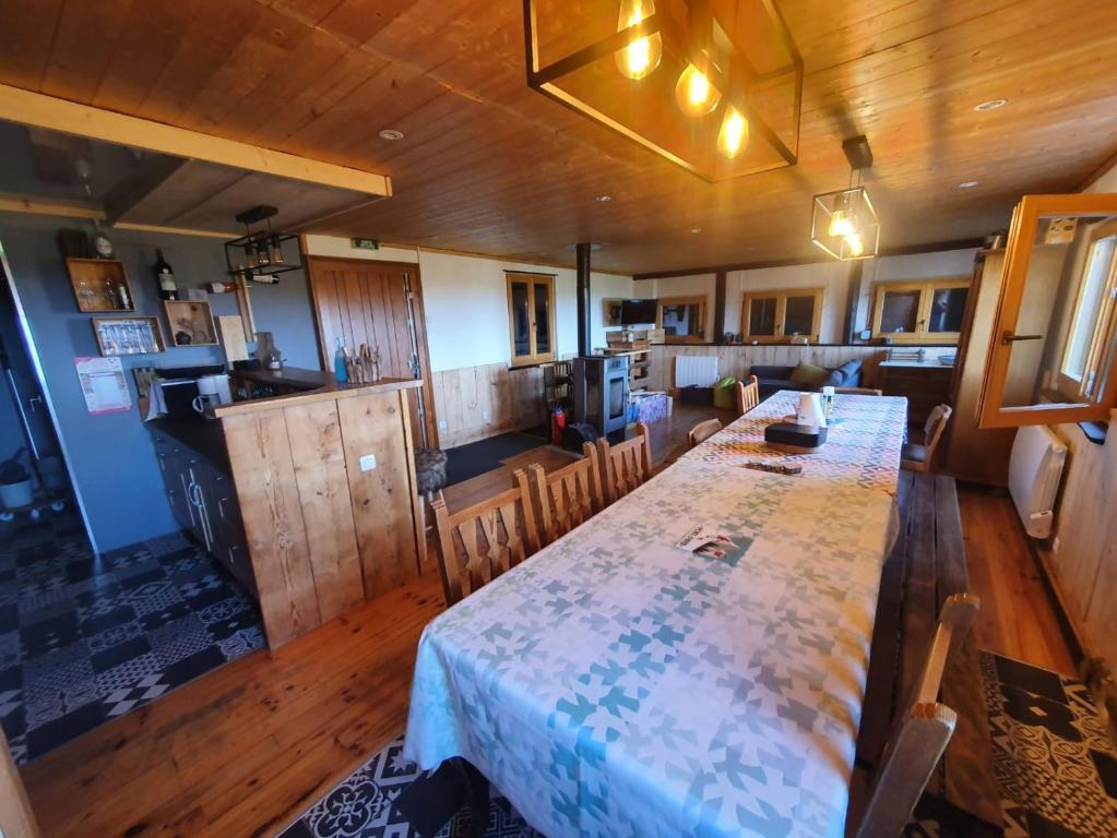 a large dining room with a table and a kitchen at Chalet ALOA in Le Bonhomme