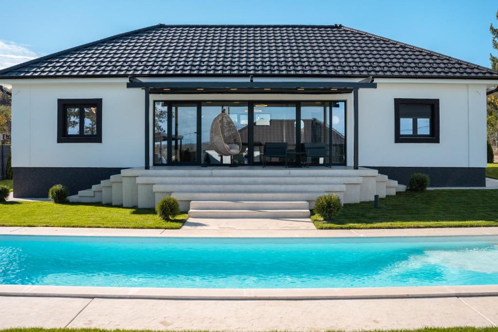 uma casa com uma piscina em frente em The Crown Pool Villa em Belgrado