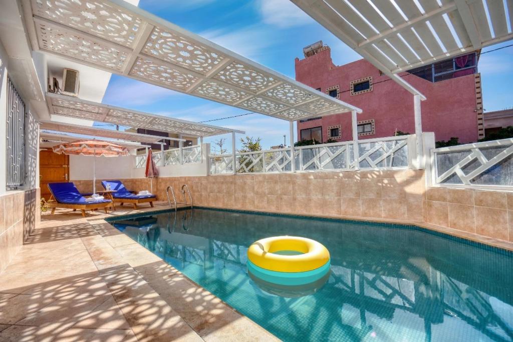 uma piscina com um remo amarelo numa casa em Cactus pool House - Luxe - 6 Px em Imsouane