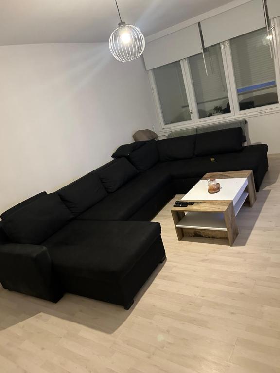 a living room with a black couch and a coffee table at Aki Apartment in Zagreb