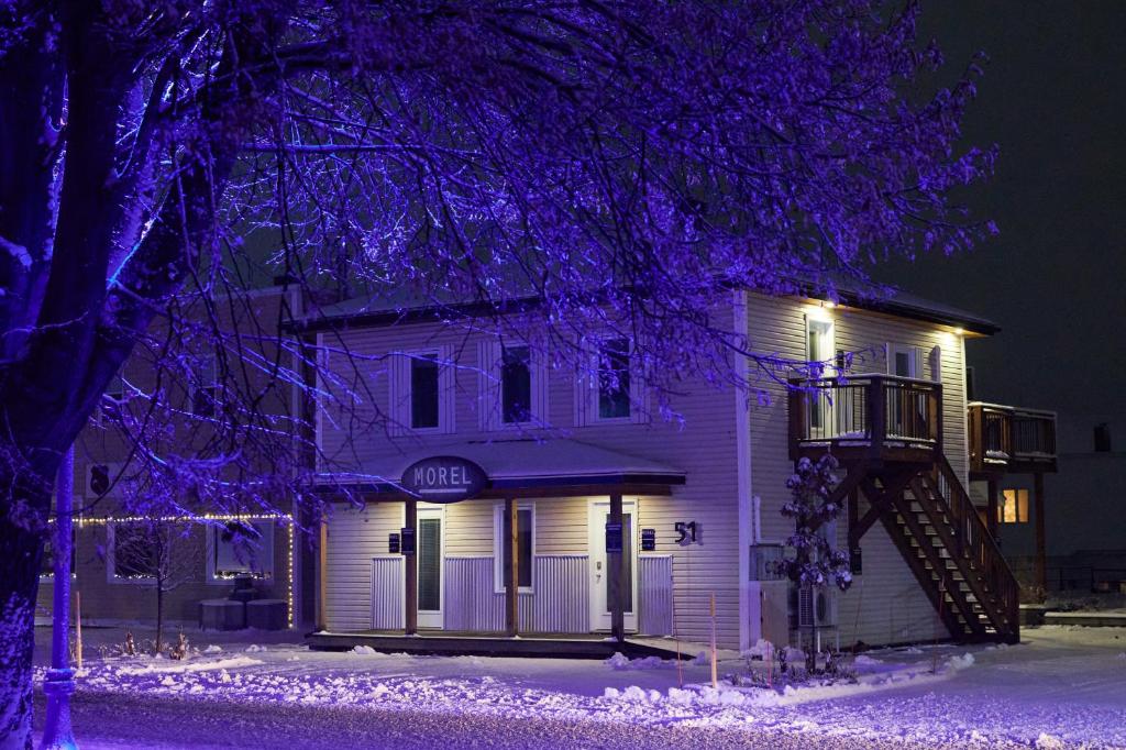 a white house with purple lights on it at Morel Executive Suites in Edmundston