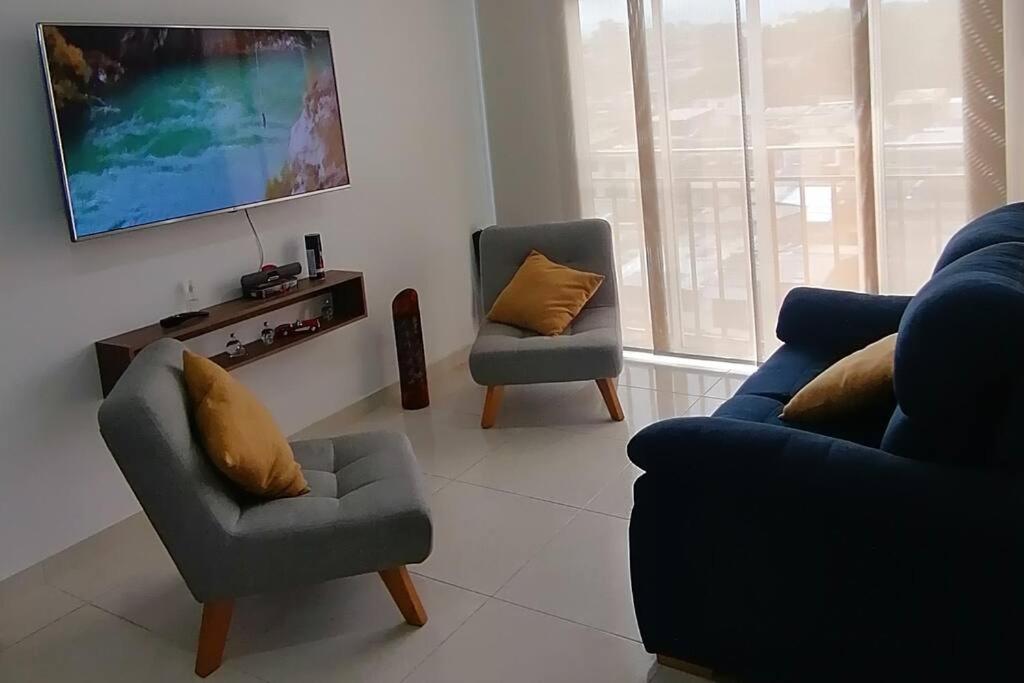 a living room with two chairs and a tv at Apartamento amoblado - Armenia Quindío. in Armenia