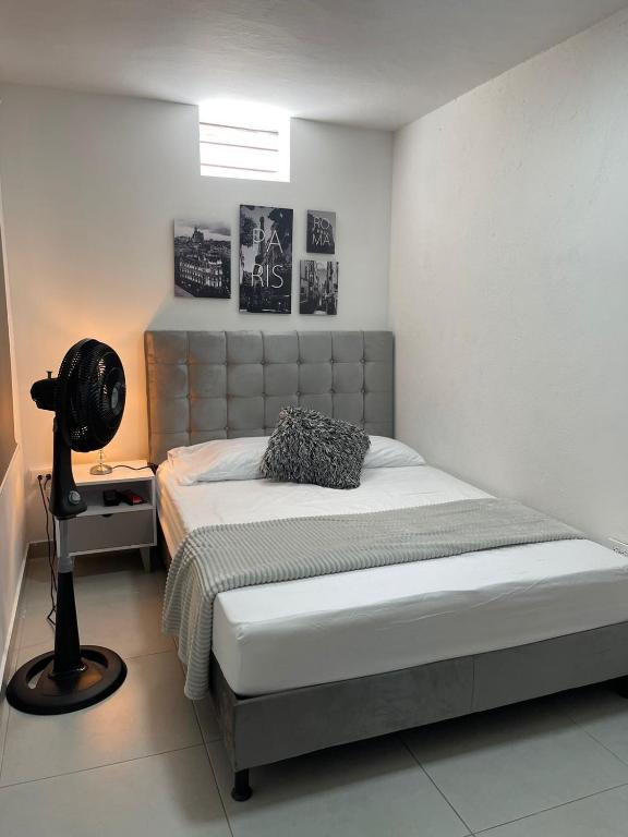 a bedroom with a bed and a lamp in it at Hotel Boutique San Joaquin Plaza in Medellín