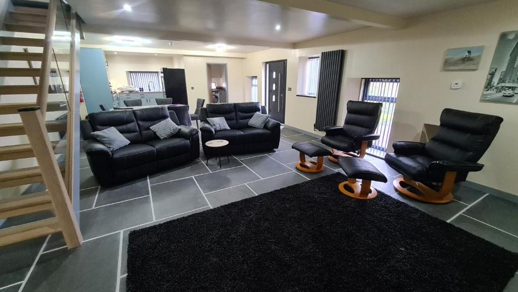 a living room with couches and chairs and a staircase at Barn near Colne for Leisure or Business in Colne