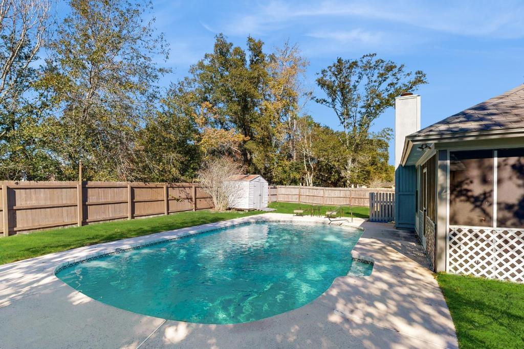 a swimming pool in a yard with a fence at Hawks Hollow Hideaway in Jacksonville