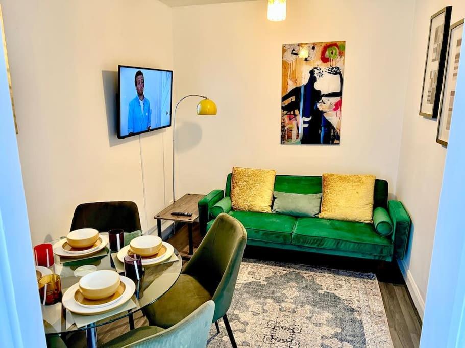 a living room with a green couch and a table at Affordable 2 bedroom flat Tower Bridge/Bermondsey in London
