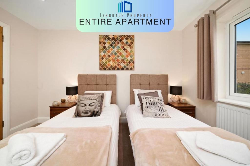 - 2 lits dans une chambre avec un panneau indiquant l'entrée privée de l'appartement dans l'établissement London Heathrow Living Serviced Apartments by Ferndale, à Stanwell