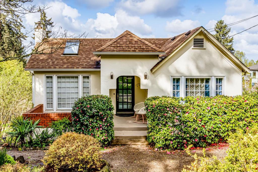 a white house with a gate and bushes at Villa Roma in Eugene