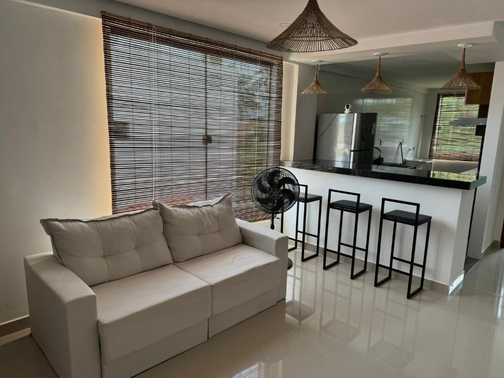 ein Wohnzimmer mit einem weißen Sofa und einer Küche in der Unterkunft Apartamento Tulum in Barra Grande