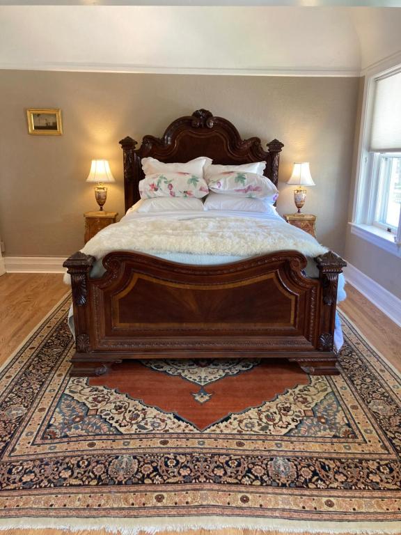 una camera da letto con un grande letto in legno con cuscini di Pineapple House, Romantic 2 Bed 2 Bath Apt, Sleeps 6! Private Balcony! City Center! FREE Parking! a Denver